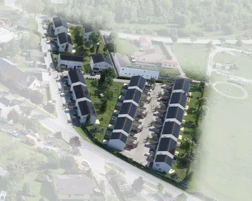 Luftaufnahme einer geplanten Wohnsiedlung mit mehreren Häusern und Solaranlagen auf den Dächern.
