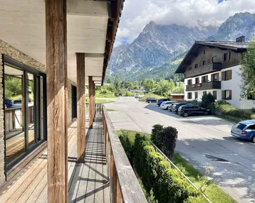 Geräumiger Balkon mit Holzboden und atemberaubendem Blick auf die umliegende Berglandschaft.