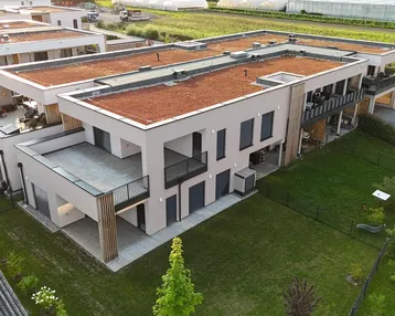 Moderne Wohnanlage mit Flachdächern und begrünten Dächern in ländlicher Umgebung.