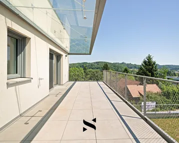 Große, sonnige Terrasse mit Fliesenboden, Glasüberdachung und weitem Blick ins Grüne.