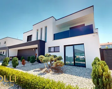 Moderne weiße Villa mit minimalistischer Gartengestaltung und integrierter Garage.