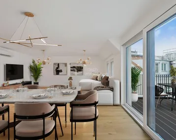 Moderner Wohn-Essbereich mit stilvollen Möbeln, Holzboden und Zugang zu einer sonnigen Terrasse.