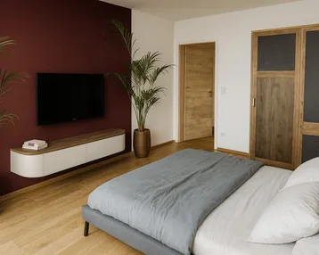Modernes Schlafzimmer mit Holzboden, einer Akzentwand in Bordeauxrot und integriertem TV-Bereich.