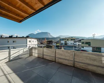 Große Terrasse mit Fliesenboden und weitem Blick auf die umliegende Berglandschaft.