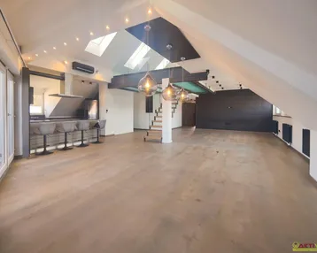 Geräumiger offener Wohnbereich mit moderner Küche, Holzboden und Dachfenstern, ideal für geselliges Beisammensein.