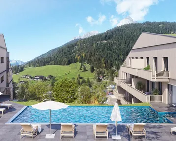 Außenpoolbereich mit Liegestühlen und beeindruckendem Blick auf die grüne Berglandschaft.