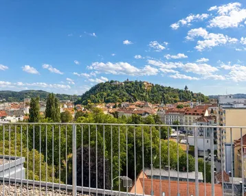 Geräumige Dachterrasse mit weitem Blick über die Stadt und den grünen Schlossberg.