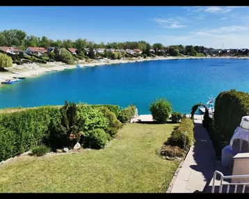 Gepflegter Gartenbereich mit direktem Zugang zum See und weitem Blick über das Wasser.