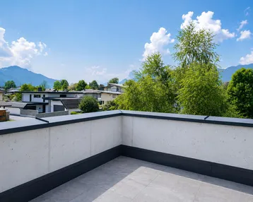Geräumige Dachterrasse mit Fliesenboden und weitem Blick auf die umliegende Berglandschaft.