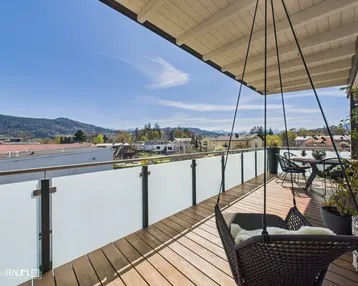 Geräumige Dachterrasse mit Holzboden, Hängesessel und weitem Blick auf die Berge und die Umgebung.