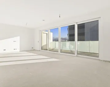 Heller, unmöblierter Raum mit großen Schiebetüren und Zugang zu einem Balkon, bietet Bergblick.
