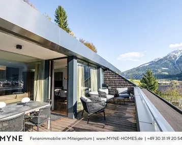 Große Dachterrasse mit modernen Outdoor-Möbeln, Esstisch und atemberaubendem Bergblick, ideal zum Entspannen.