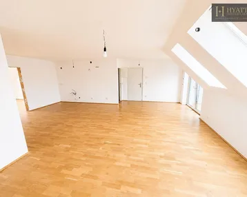 Helles, geräumiges Zimmer mit Holzparkettboden und Dachschrägen, bereit für individuelle Gestaltung.