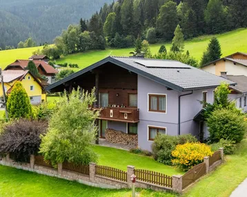 Traditionelles Haus mit Satteldach, Photovoltaikanlage und gepflegtem Garten in ländlicher Umgebung.