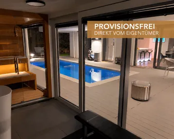 Moderner Innenbereich mit Sauna und Fitnessbank, mit Blick auf den beleuchteten Pool und die Terrasse.