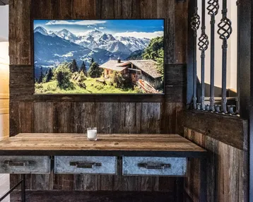 Flurbereich mit Holzwänden, rustikalem Konsolentisch und großem Bergpanorama-Bild.