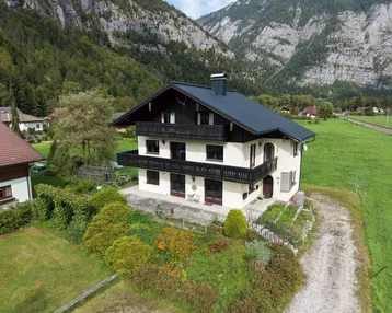Traditionelles Chalet in den Bergen mit mehreren Balkonen, Terrasse und großem Garten.