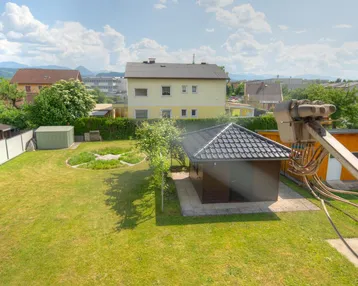 Großer, gepflegter Garten mit Rasenfläche, Gartenhaus und Bergblick in ruhiger Lage.