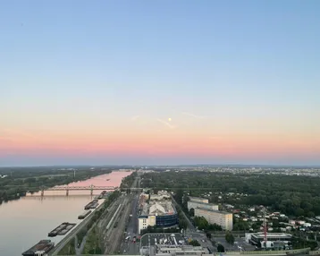 Panoramablick über die Donau und die Stadt bei Sonnenaufgang mit rosa Himmel.