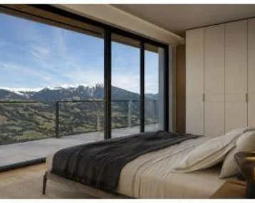 Schlafzimmer mit raumhohen Fenstern, die einen atemberaubenden Blick auf die Berge bieten.