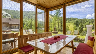 Sonniger Wintergarten mit Blick auf die Skipiste