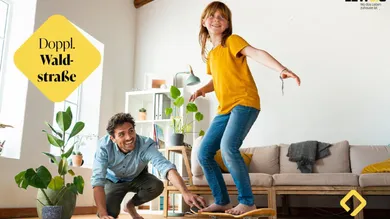 Immo_2-Zimmerwohnung_Kind_mit_Vater_auf_Skateboard_im_Wohnzimmer_GettyImages-1308856260
