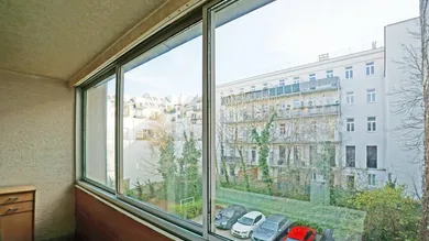 Ausblick von der Südloggia in den Hof mit Parkplatz und Garten