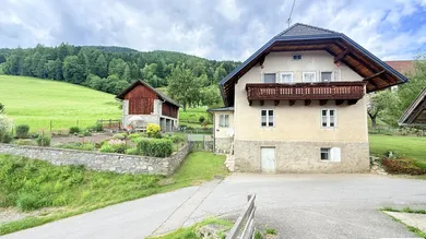 Haus außen mit Nebengebäude und Gemüsegarten