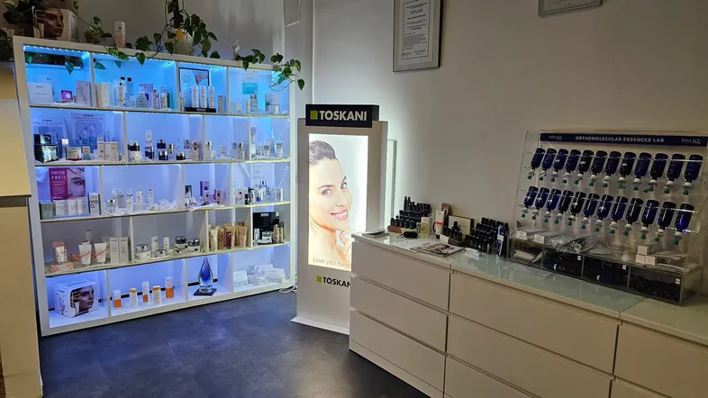 Verkaufsbereich mit beleuchteten Regalen voller Kosmetikprodukte und einem Werbedisplay für Schönheitsprodukte.