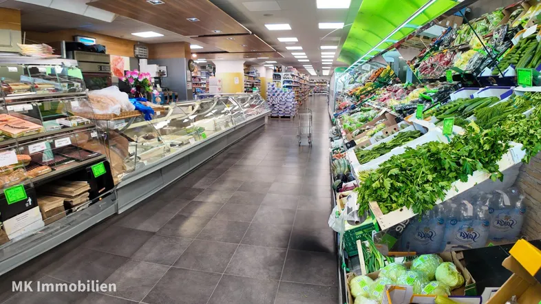 Geräumiger Supermarkt mit frischer Obst- und Gemüseabteilung sowie einer gut bestückten Fleisch- und Käsetheke.