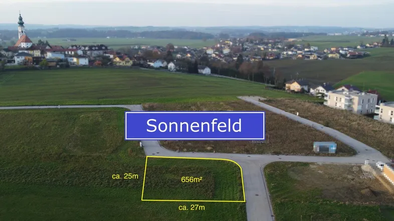 Luftaufnahme eines Baugrundstücks in Sonnenfeld mit markierter Fläche und umliegender Wohnbebauung.