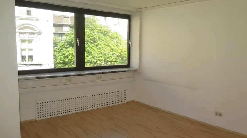 Helles Büro mit großen Fenstern, Laminatboden und Blick ins Grüne, ideal für produktives Arbeiten.