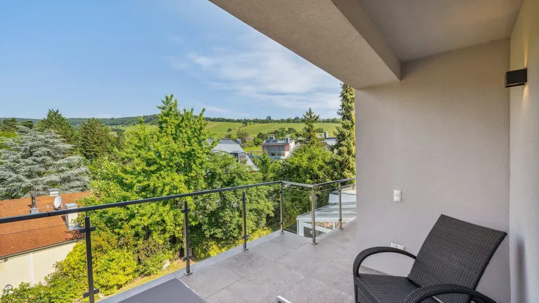 Geräumiger Balkon mit moderner Bestuhlung und weitem Blick ins Grüne.