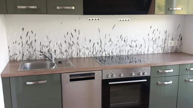 Moderne Einbauküche in Olivgrün mit Spülmaschine, Backofen und Induktionskochfeld.