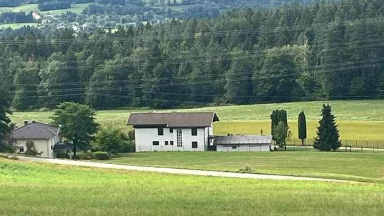 Ländliches Anwesen mit Einfamilienhaus und weitem Blick über grüne Felder und Wälder.
