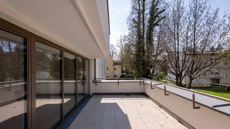 Geräumiger Balkon mit Fliesenboden und Blick ins Grüne, ideal zum Entspannen.
