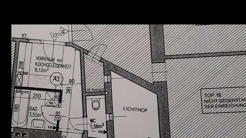 Grundriss einer Wohnung mit mehreren Zimmern, Bad, WC und einem Lichthof für natürliche Belichtung.