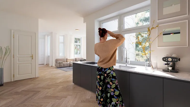 Moderne Küche mit dunklen Unterschränken, heller Arbeitsplatte und Blick ins Grüne.