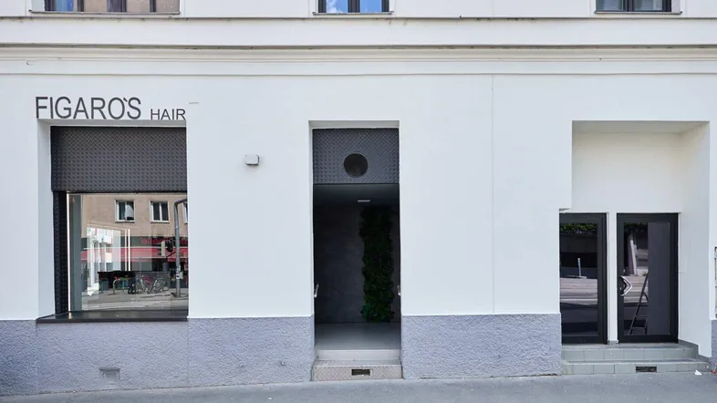 Fassade des Gebäudes mit Schaufenstern und Eingangsbereich im Erdgeschoss.
