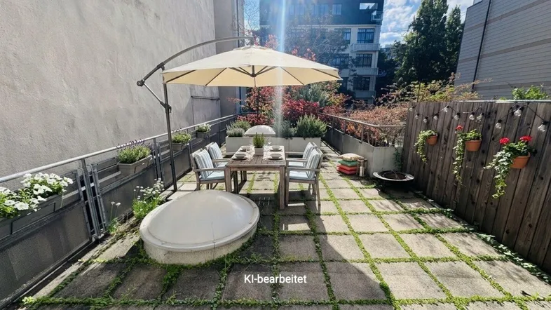 Geräumige Terrasse mit Steinplatten, Gartenmöbeln, Sonnenschirm und Pflanzen, ideal für Entspannung im Freien.
