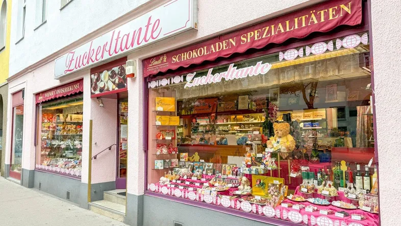 Traditionelles Süßwarengeschäft mit rosa Fassade und großen Schaufenstern voller Spezialitäten.