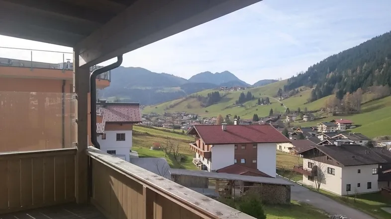 Geräumiger Balkon mit Holzboden und atemberaubendem Blick auf die umliegende Berglandschaft.