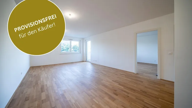 Helles, leeres Wohnzimmer mit Parkettboden und Zugang zu einem Balkon, bereit zum Einzug.
