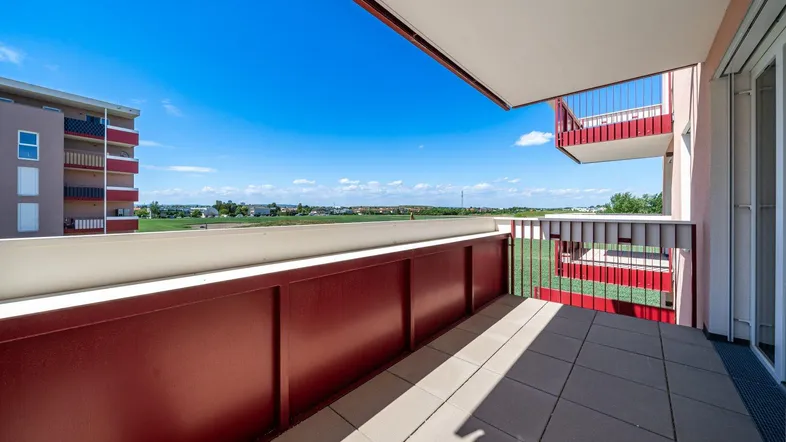 Heller Balkon mit Fliesenboden und weitem Blick über die umliegende Landschaft.