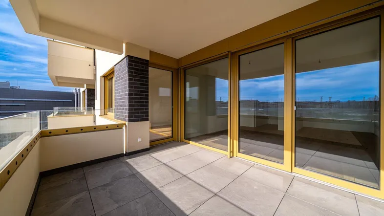 Geräumige Terrasse mit Fliesenboden und Glasgeländer, ideal für entspannte Stunden im Freien.