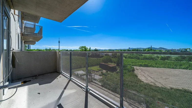 Geräumiger Balkon mit weitem Blick über grüne Felder und die Umgebung, ideal für entspannte Stunden.