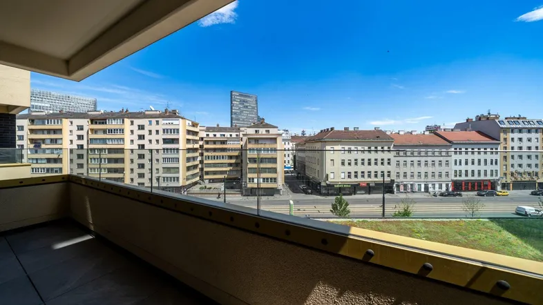 Geräumiger Balkon mit Glasbrüstung bietet einen weiten Blick über die Stadt und die umliegenden Gebäude.