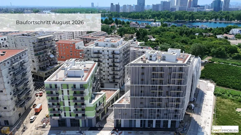 Luftaufnahme eines Neubauprojekts mit modernen Wohngebäuden und weitem Blick auf die Stadt und den Fluss.