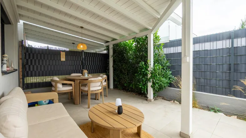 Überdachte Terrasse mit gemütlicher Sitzecke und Essbereich, ideal für entspannte Stunden im Freien.
