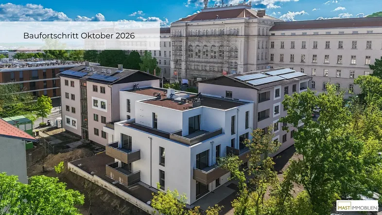 Panoramablick auf moderne Wohngebäude und ein historisches Gebäude, umgeben von üppigem Grün.